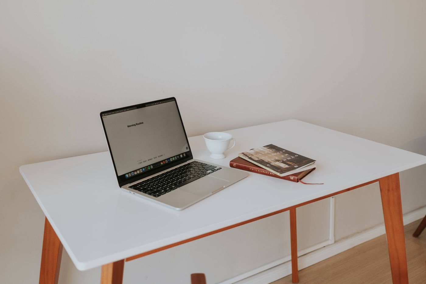 Arbeitsplatz mit Laptop, Kaffeetasse und Büchern